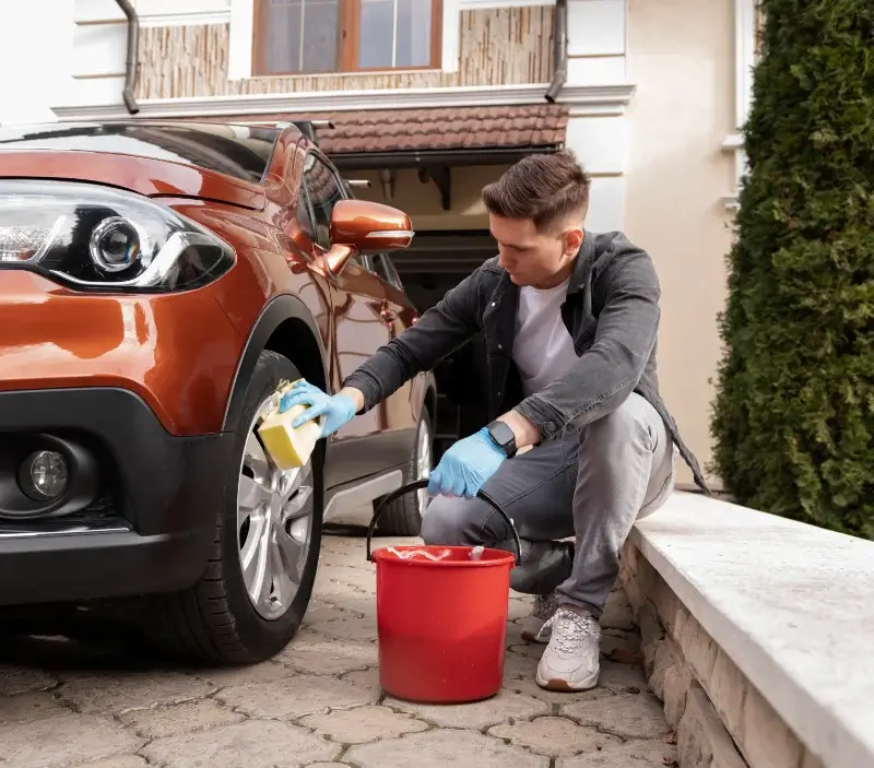 Lavage auto à domicile Grandchamp-des-Fontaines : professionnel intervenant sur un véhicule